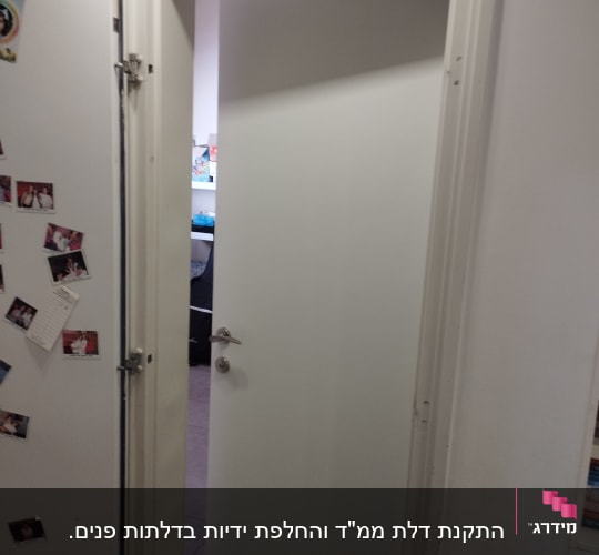 דלת לבנה פתוחה עם ידית מתכת